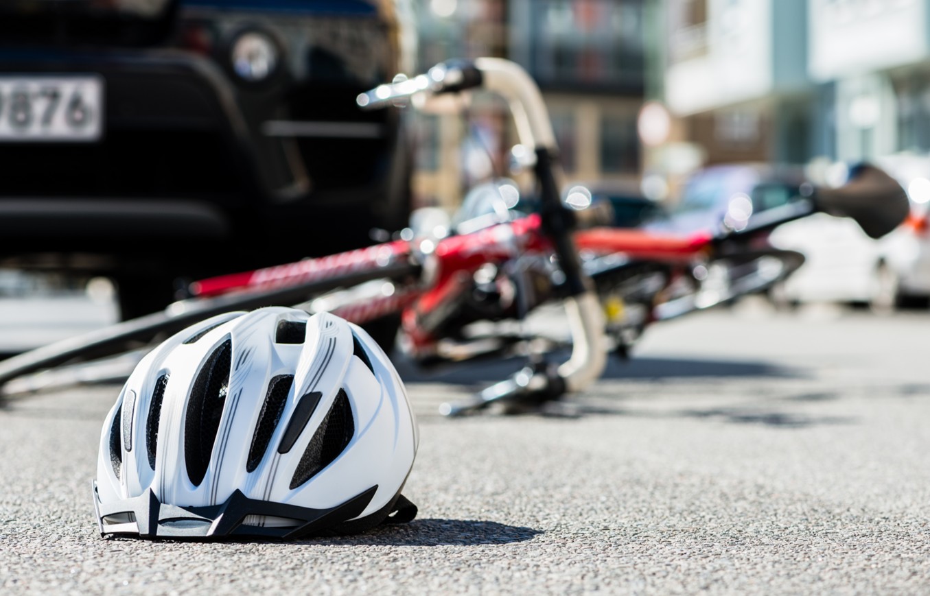 事故にあい倒れた自転車と転がったヘルメット