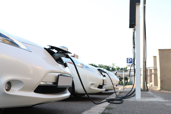 EV充電器で充電している白い電気自動車(EV車)