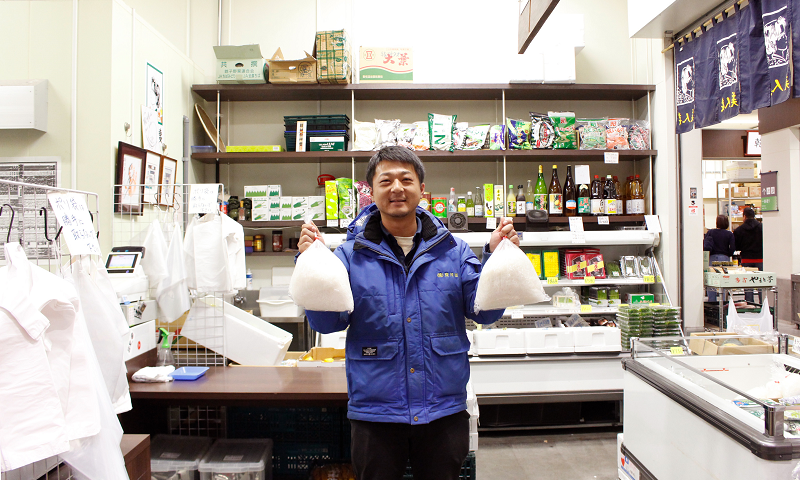 店舗前に立つ株式会社駿河屋 営業部 矢吹 賢太氏の写真